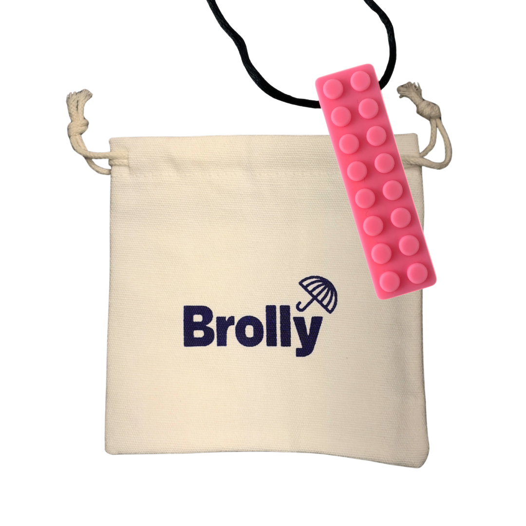 Beige drawstring pouch and brick-shaped Brolly Sheet Chew Necklace on a black cord against a white background - Pink