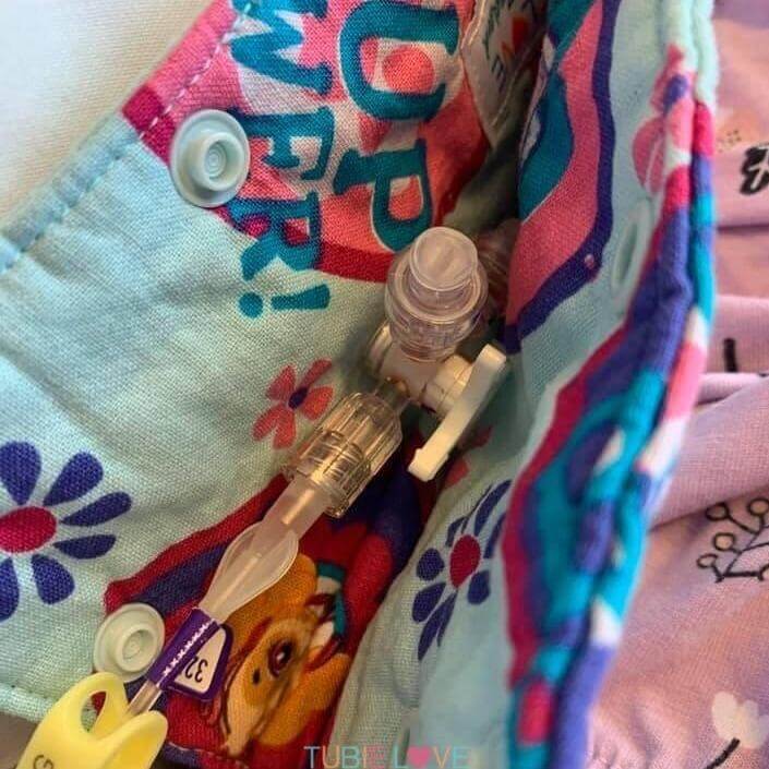 Colorful connector cover with a feeding tube fitting on a floral background