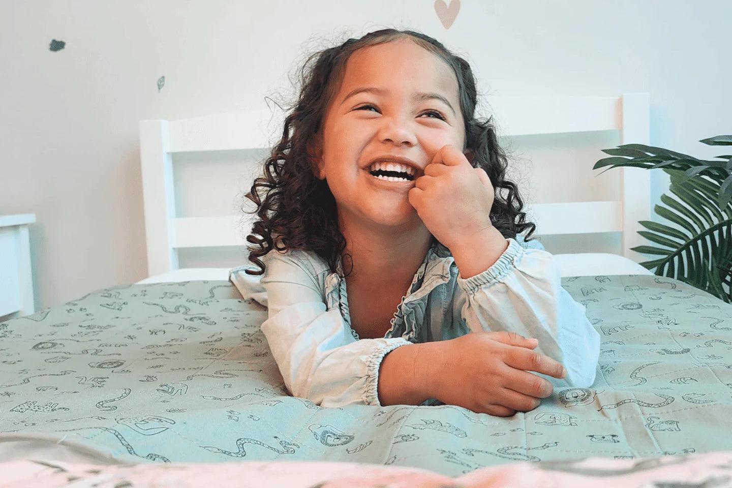 Happy little toddler girl on top of our animal kingdom Brolly Sheets with Wings Print