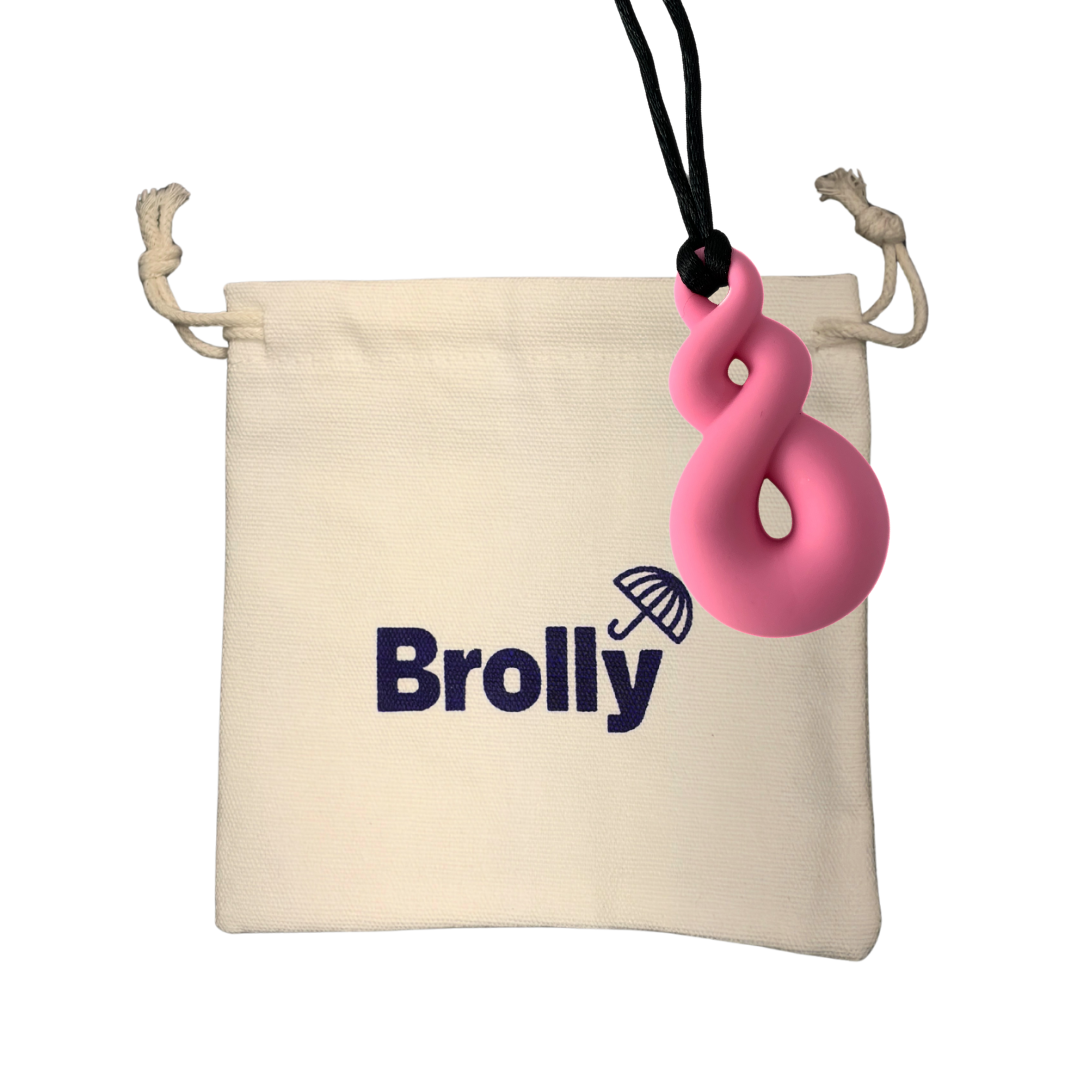 Beige drawstring pouch and Twist-shaped Brolly Sheet Chew Necklace on a black cord against a white background - Pink