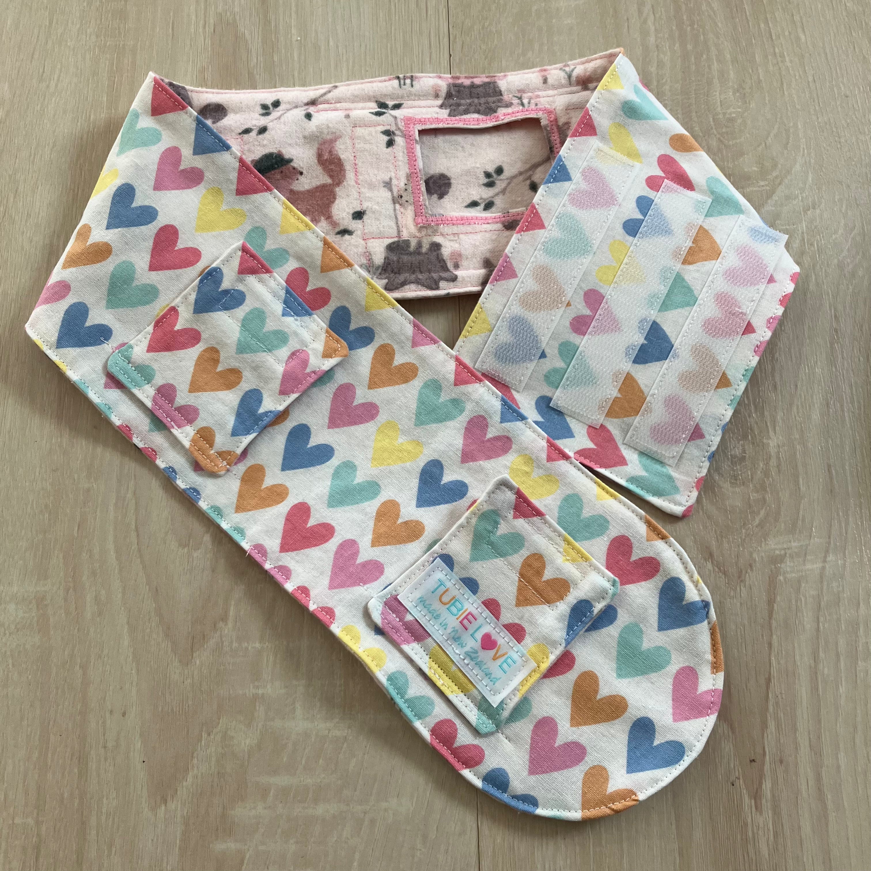 Feeding Belt with colorful heart patterns on a wooden surface